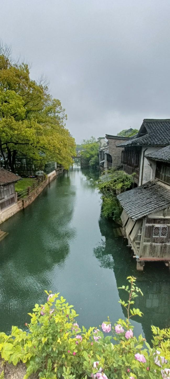 江南水乡，古韵悠长，绿树掩映，粉花点缀，静谧如画。
上联：江南水乡古韵悠，
下联