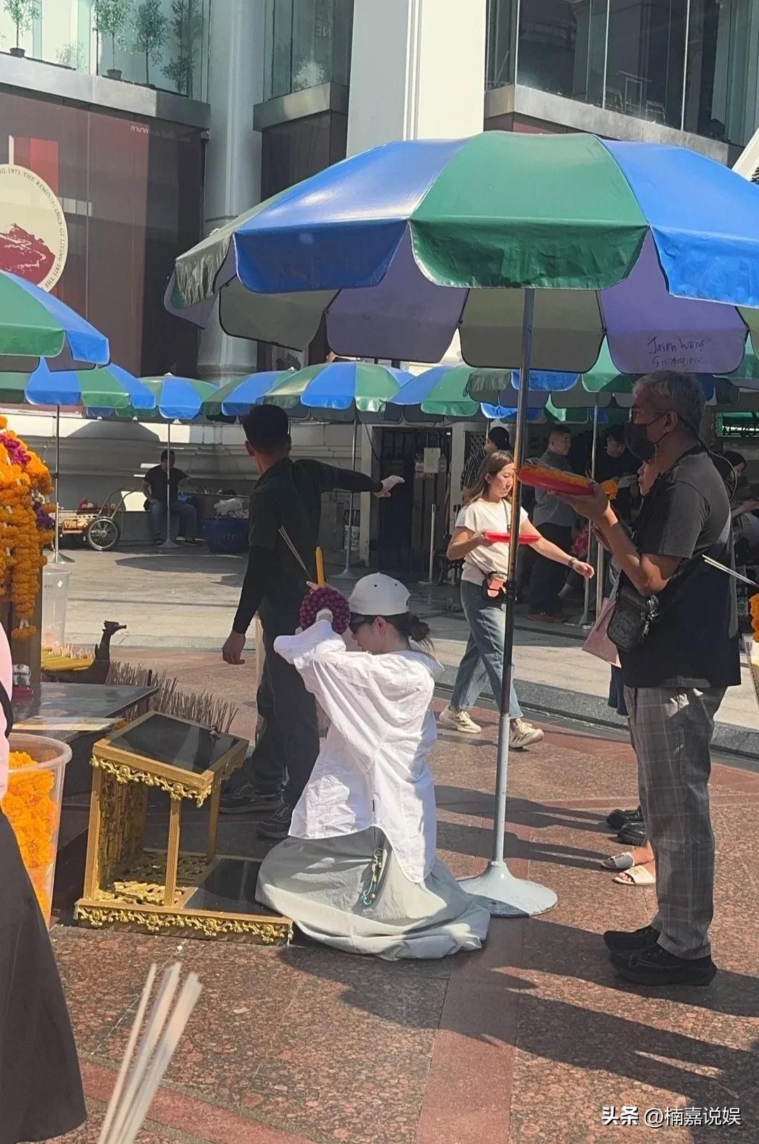 戚薇现身曼谷拜四面佛，李承铉现身陪同。
戴着棒球帽的她，穿着白色衬衣配灰色宽松裙