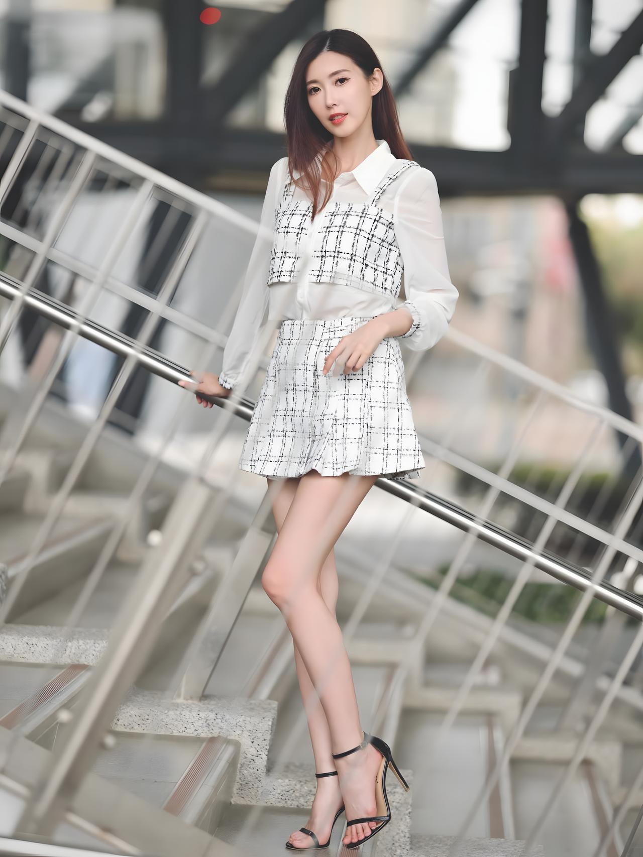 这组照片展现了都市轻熟风的优雅与干练，黑白格纹套装搭配现代建筑背景，尽显时尚气场