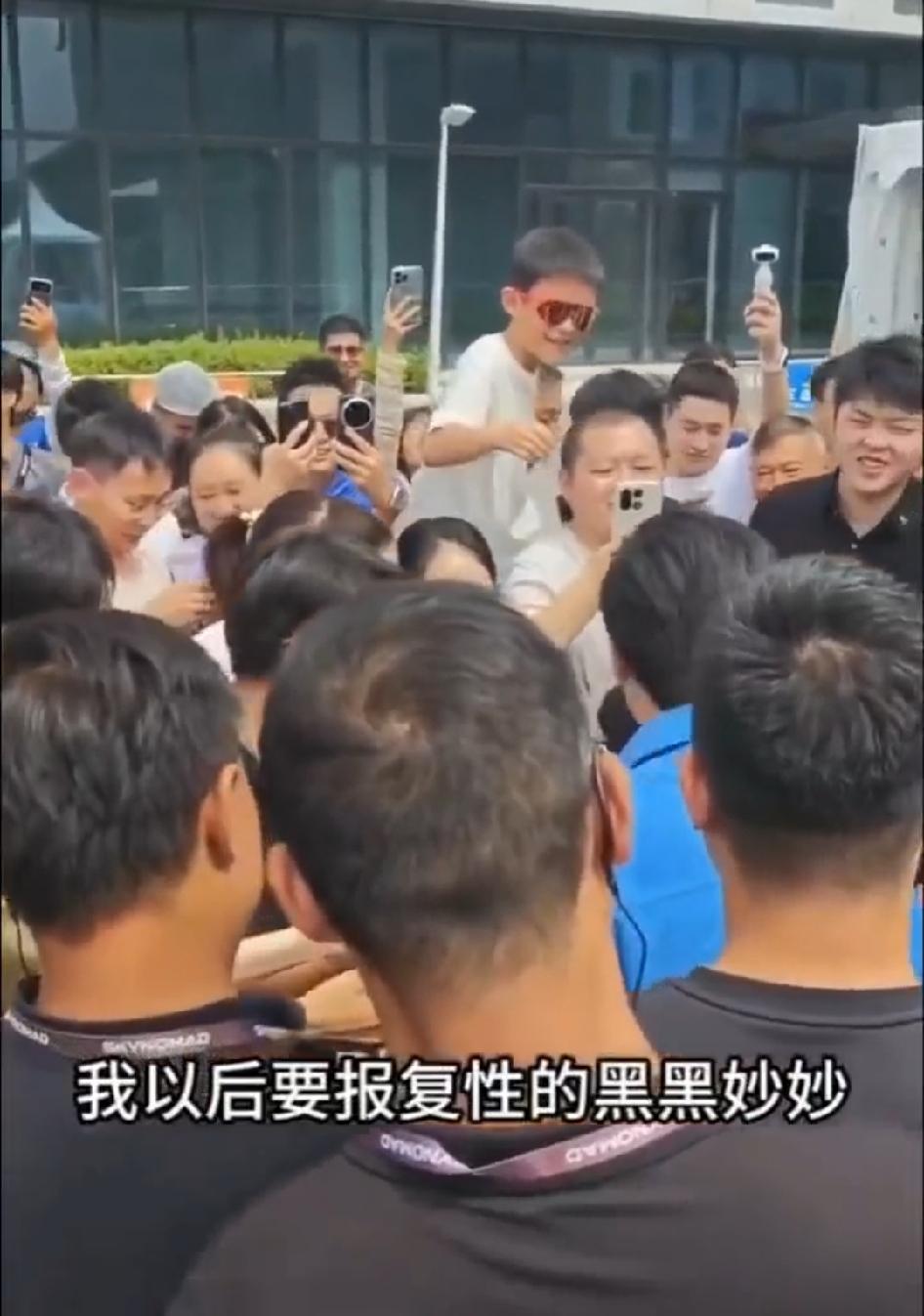 一群粉丝围着雷总要签名，雷总乐此不疲。
其中一位要到签名的女粉丝兴奋的喊到“多谢