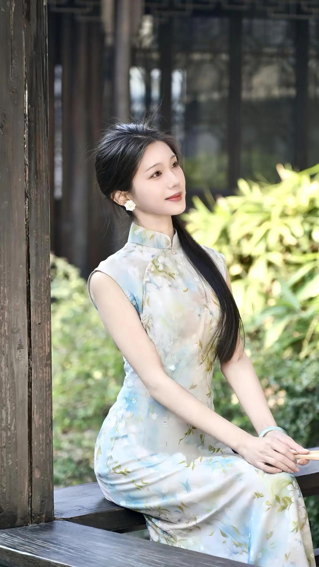 什么样的穿搭可以成为气质女神?这组照片展现了一位年轻女性身着新中式绿色旗袍，在古