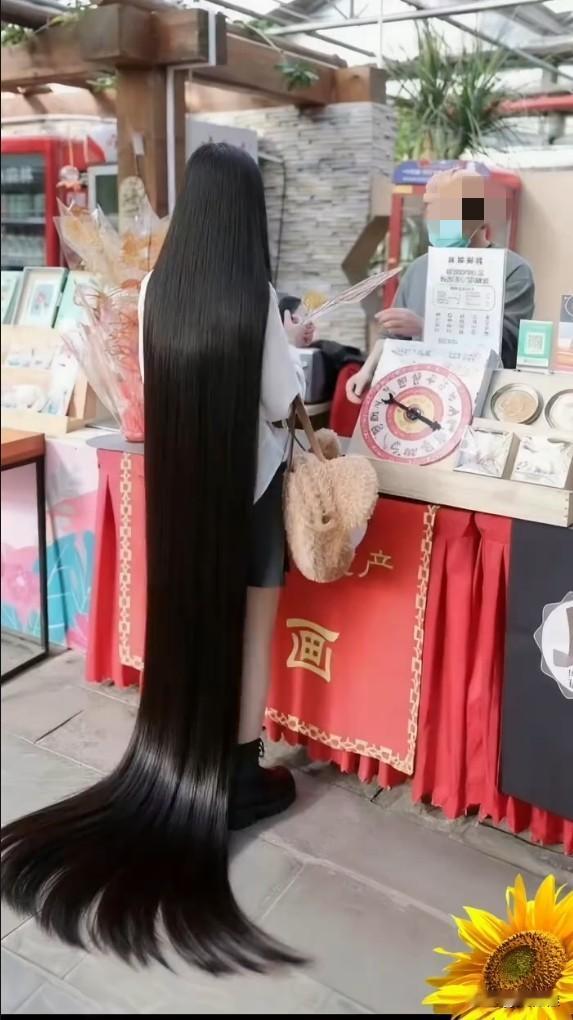 见过衣服拖地的，还没见过头发拖地的！这姑娘的头发也太长了，跟黑色瀑布似的，走哪儿