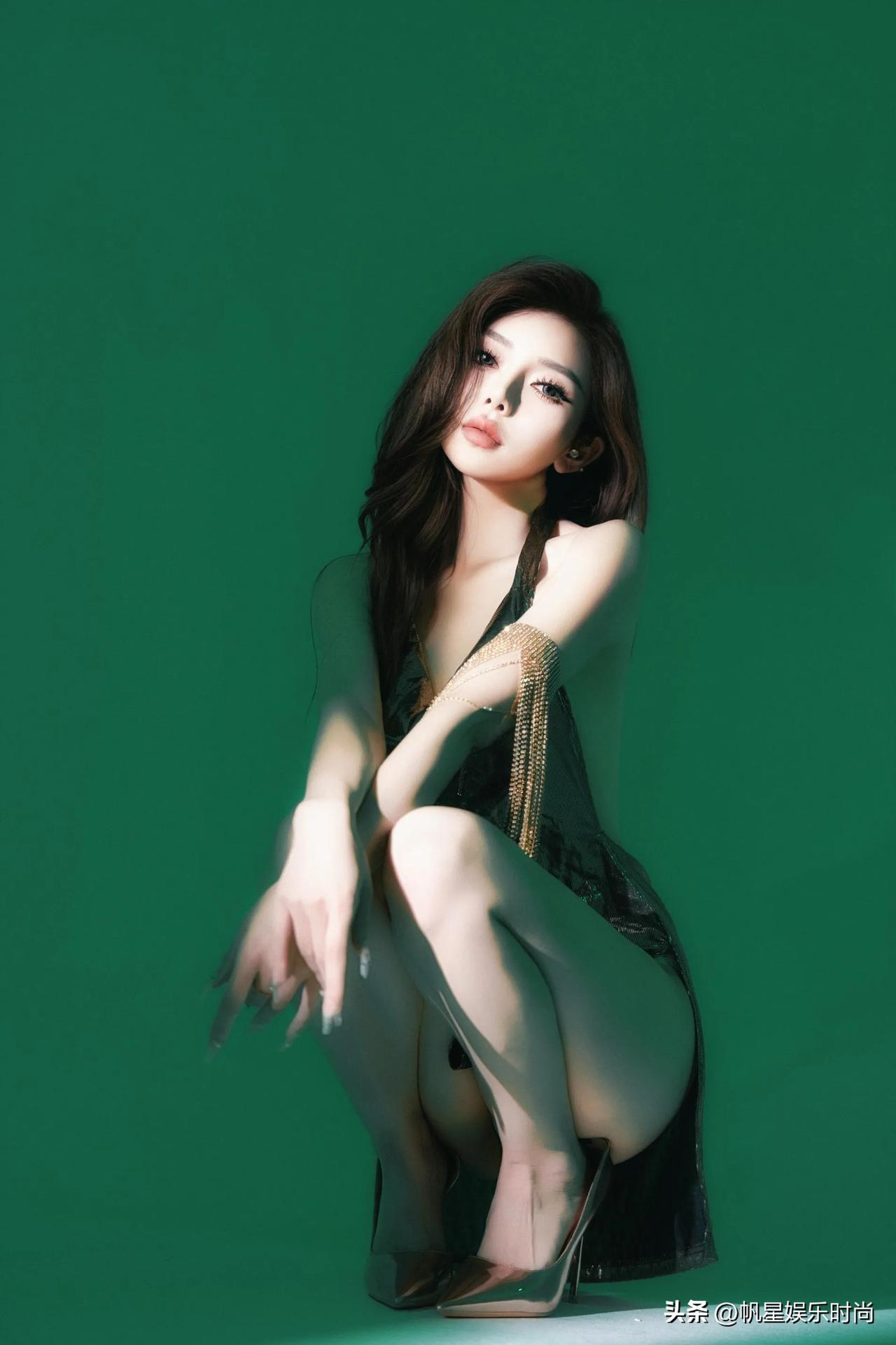 一袭露背短款裙装，金属质感的面料于光影间流转溢彩，开衩设计巧妙地勾勒出腿部线条。