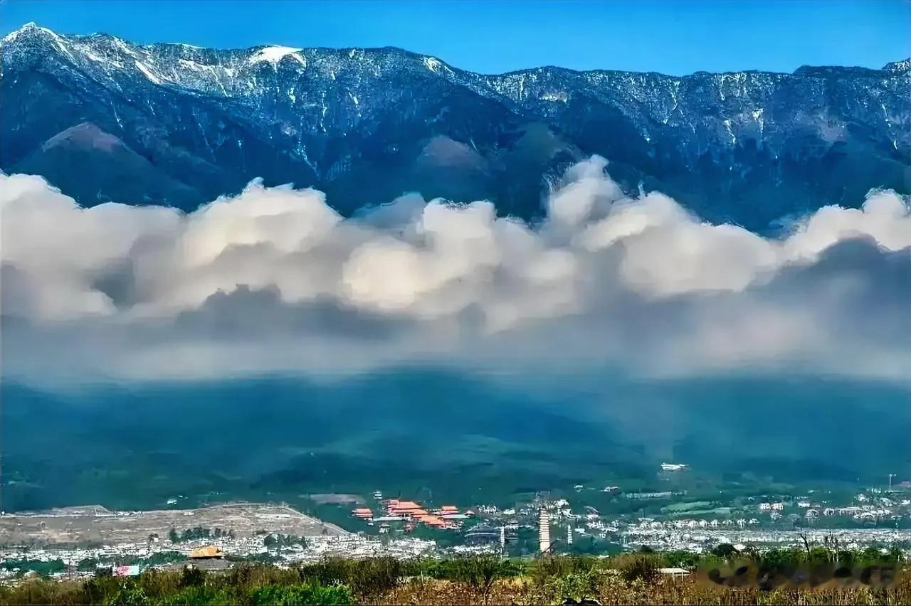 远眺白云之上的苍山与山下的大理三塔