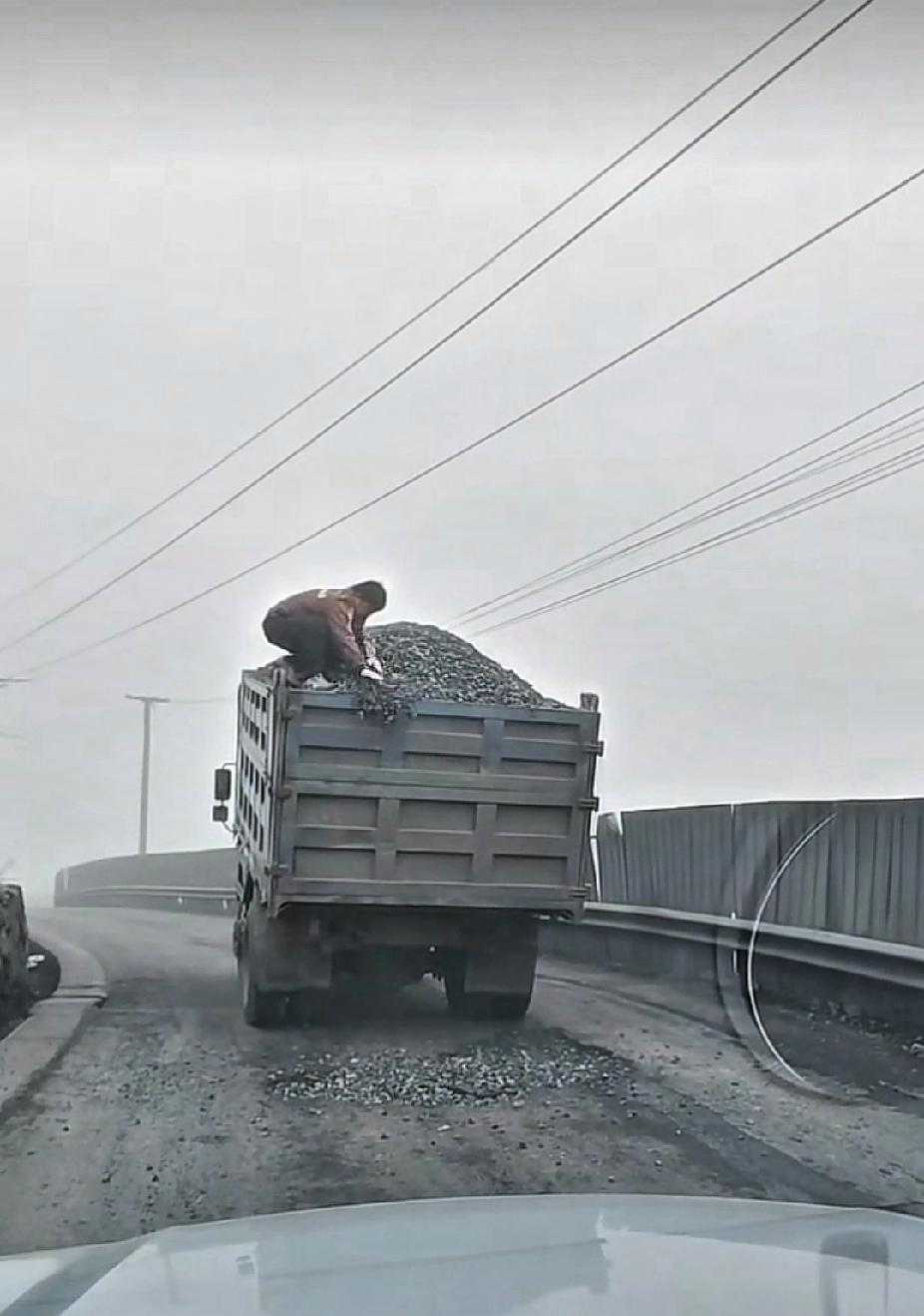 前面满载碎石子的大货车，突然挡在路中间停下了，后面小车司机刚要生气时，却被眼前的