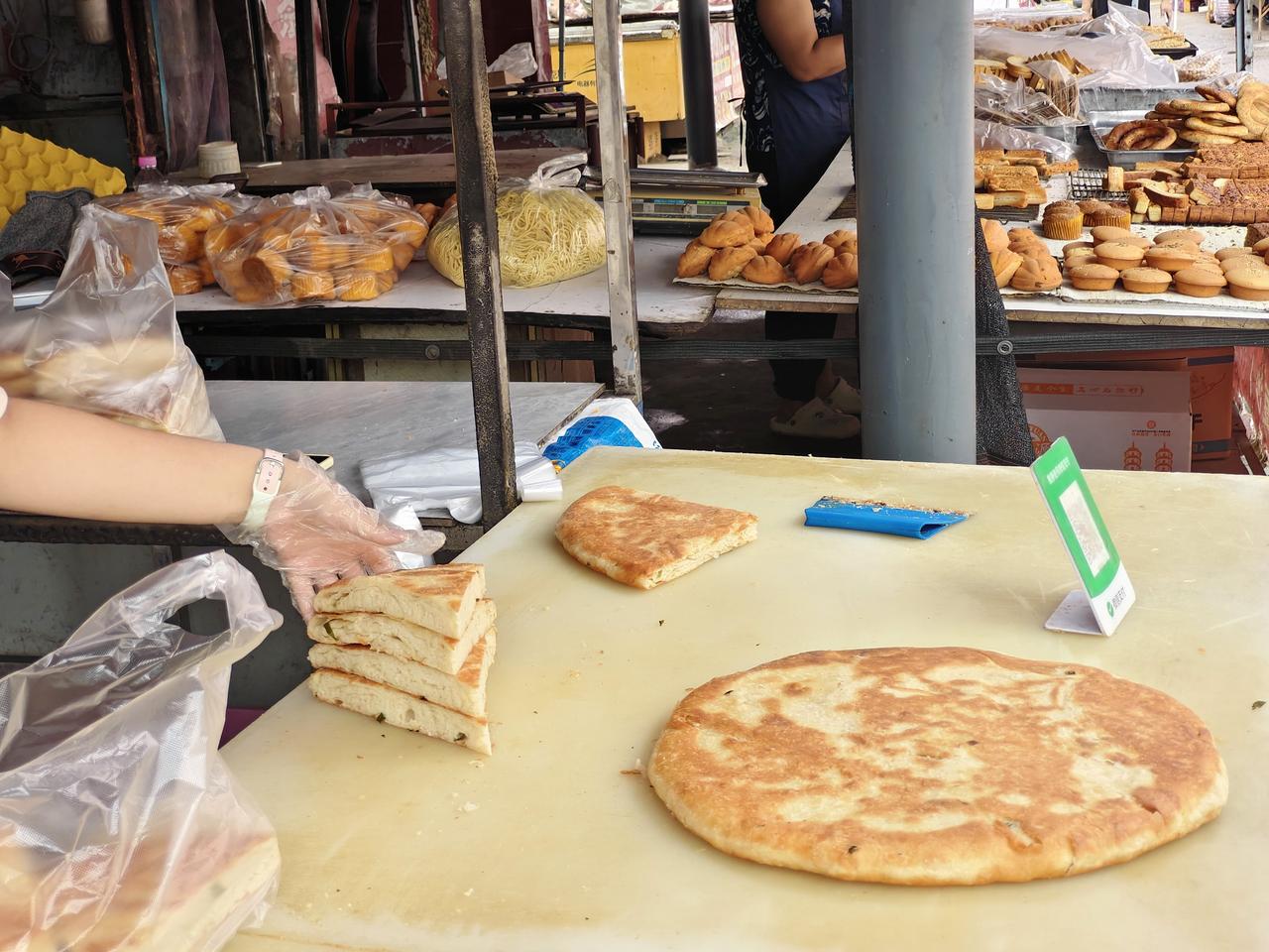 在运城盐湖西街早市，眼前的这一大张饼卖16元一张，因为这张饼从中分成四块，每块再