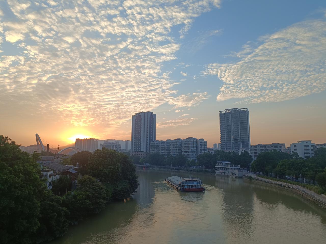 夕阳西下的河流，
躺着一般小船，
这美景让我醉了。