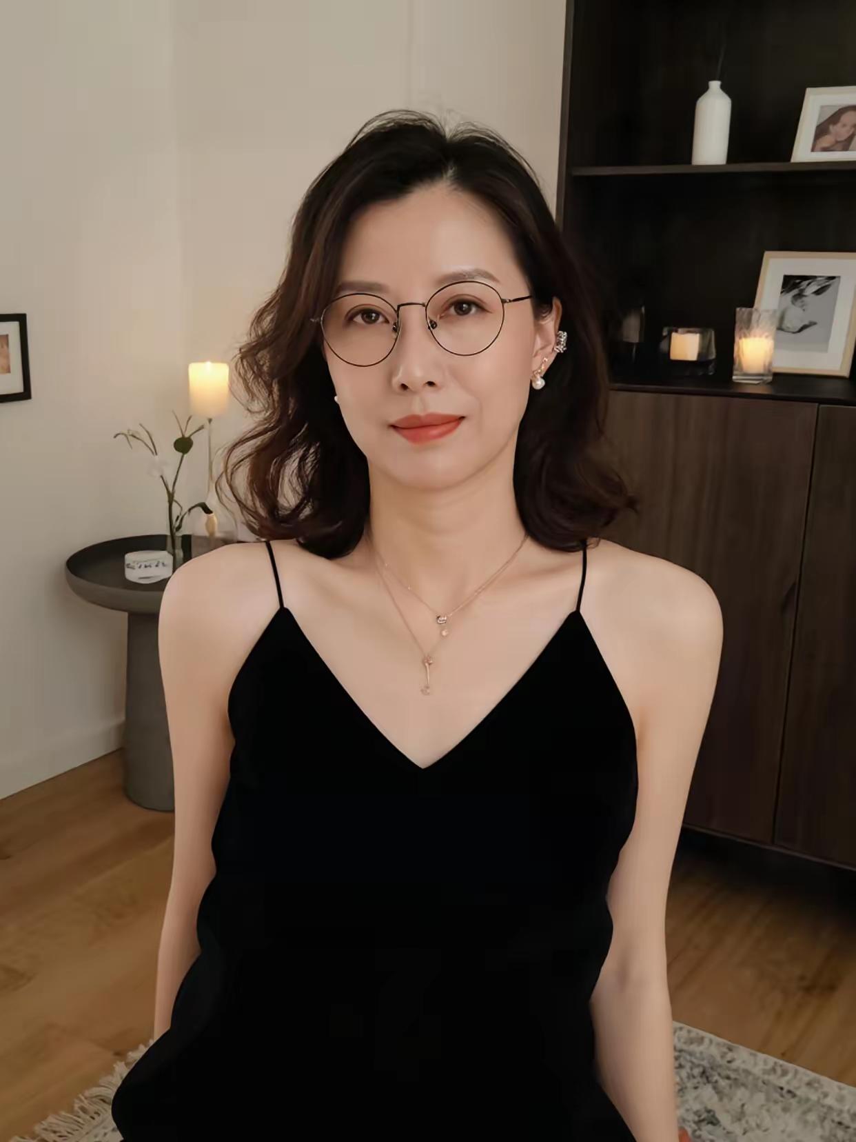 黑色连衣裙，戴着眼镜，看起来很优雅。吊带气质黑裙