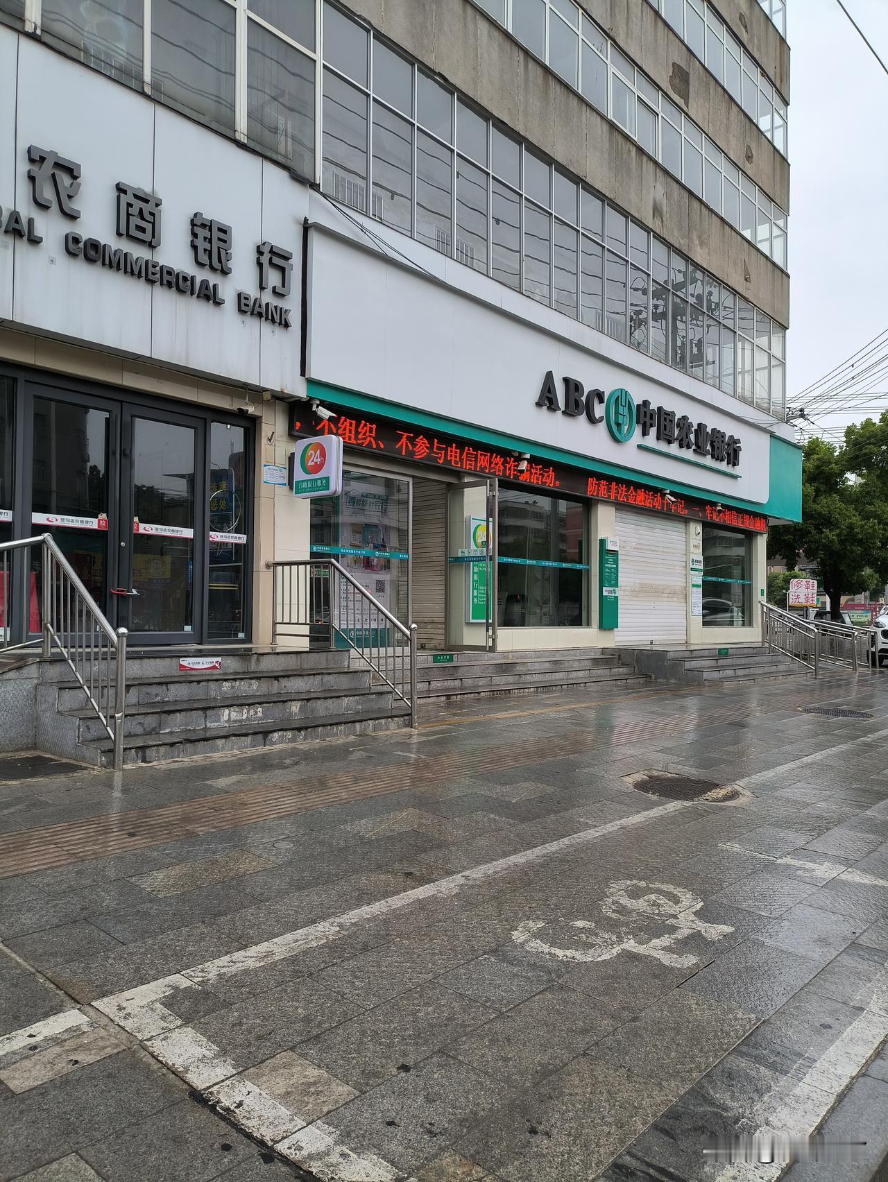 两家银行挨着，一家是农商银行，一家是农业银行。农商银行正在开着门，而农业银行今天