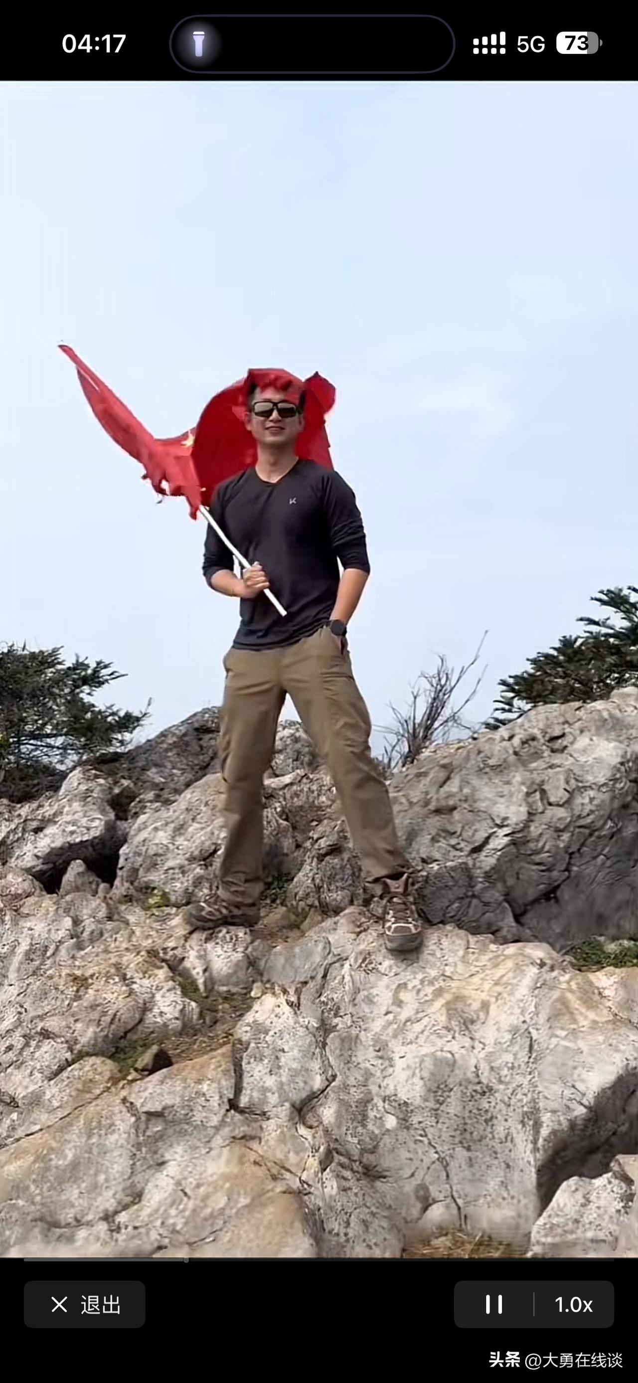 刚才刷到一个视频，一男子拿着国旗在山顶上拍摄视频。
本来这是一件很平常的事情，但