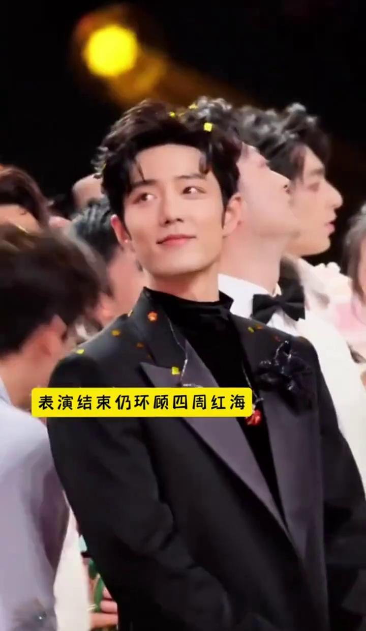 灯牌瞬间点亮。
尖叫撕裂空气。
肖战站在光里，目光扫过台下——不是扫，是吞噬。