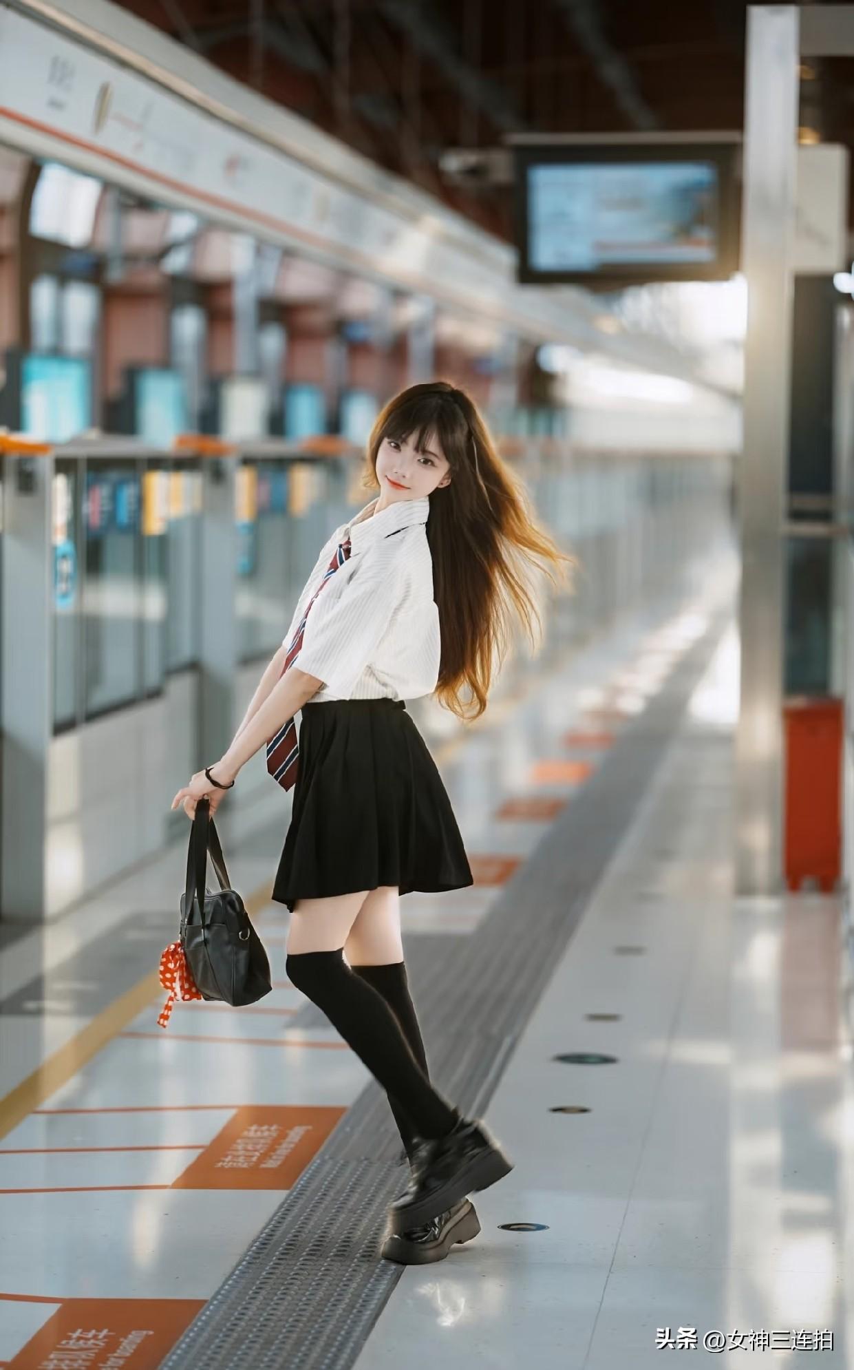 一个穿校服的女孩在地铁站。