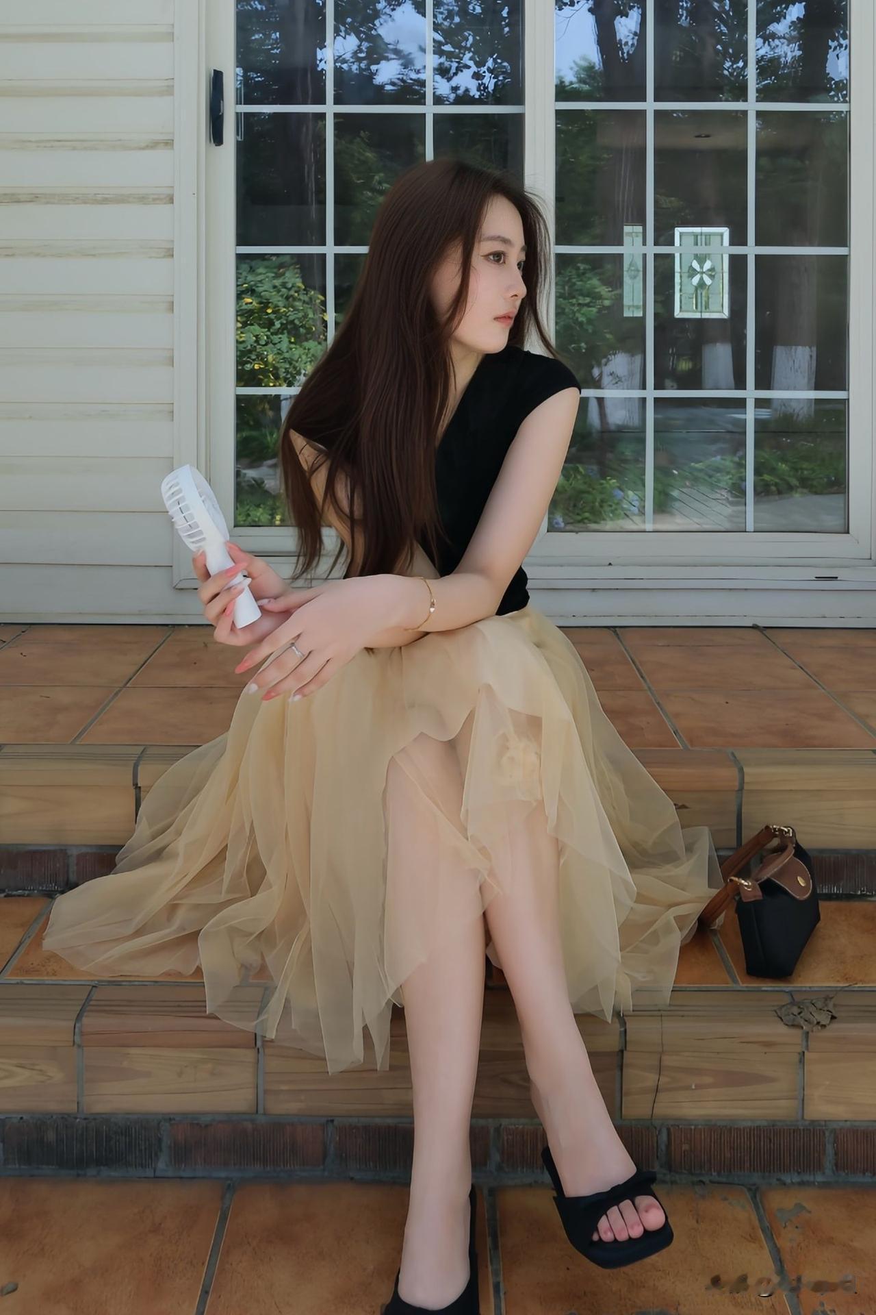 黑白撞色永远耐看，简约黑色无袖上衣利落修身搭配浅杏色网纱半身裙，沉稳与温柔相互中