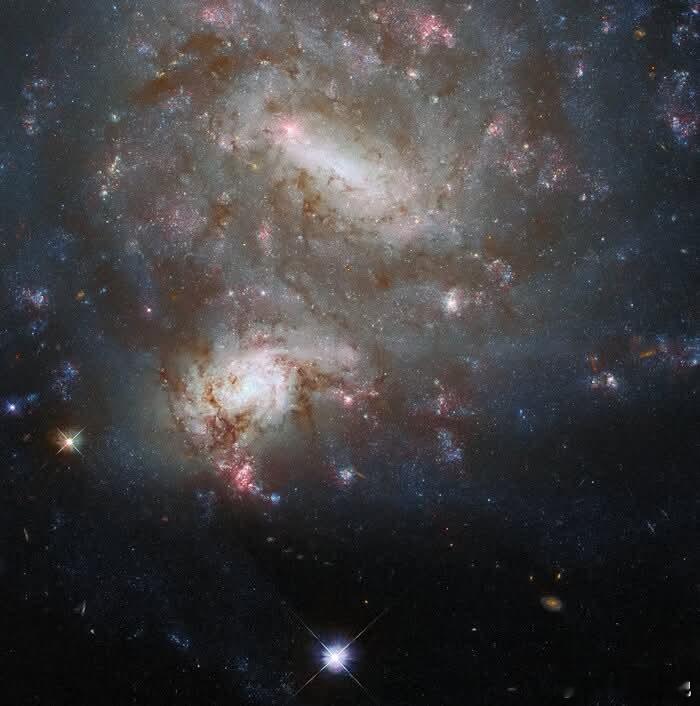 宇宙幻象：两个相隔天涯的星系看似两个螺旋星系优雅的舞蹈，实则是纯粹的天体魔术。通