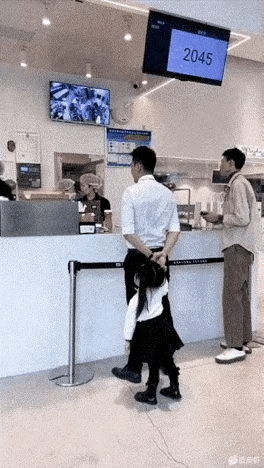 小女孩真会来事儿哦！
父女正在甜品店买零食，小女孩看见在不远处有一个漂亮姐姐，小