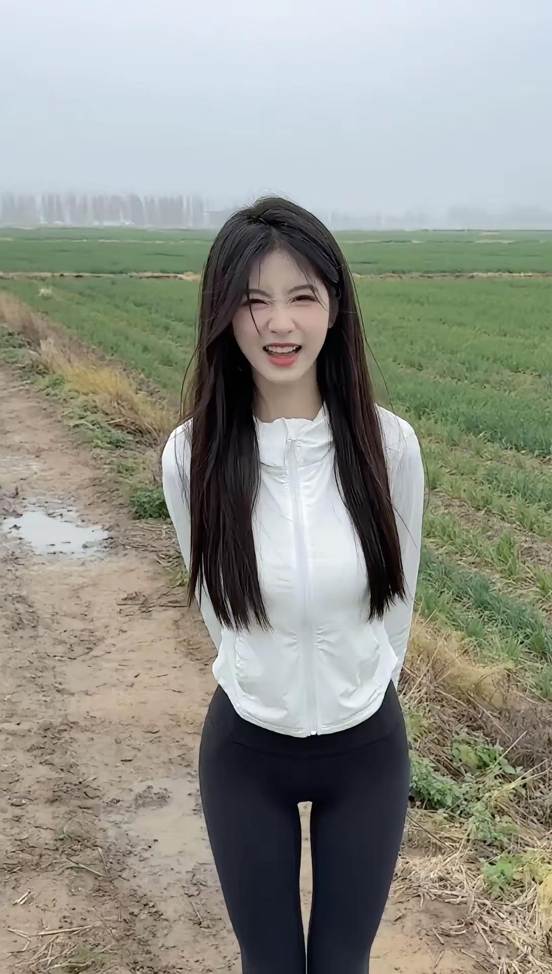 这姑娘在田间小路上笑得真开心。乡间小姐姐