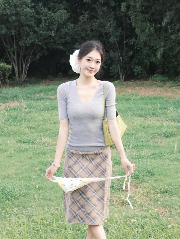 发间那团白软乎乎地坠着，衬得笑眼弯出甜意。
指尖轻攥着小花扇，扇面的细碎图案跟着