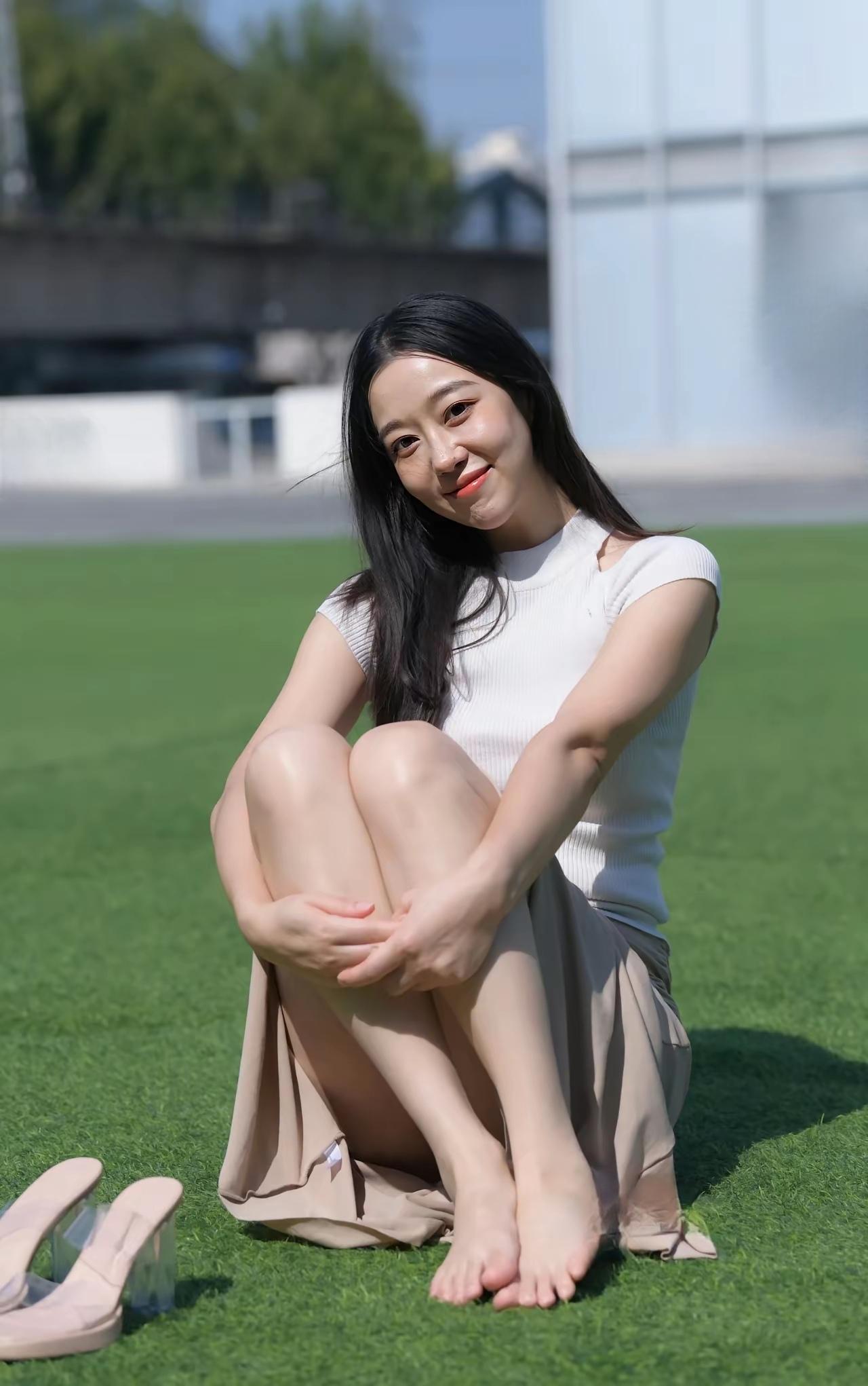 阳光明媚，女孩在草地上放松。