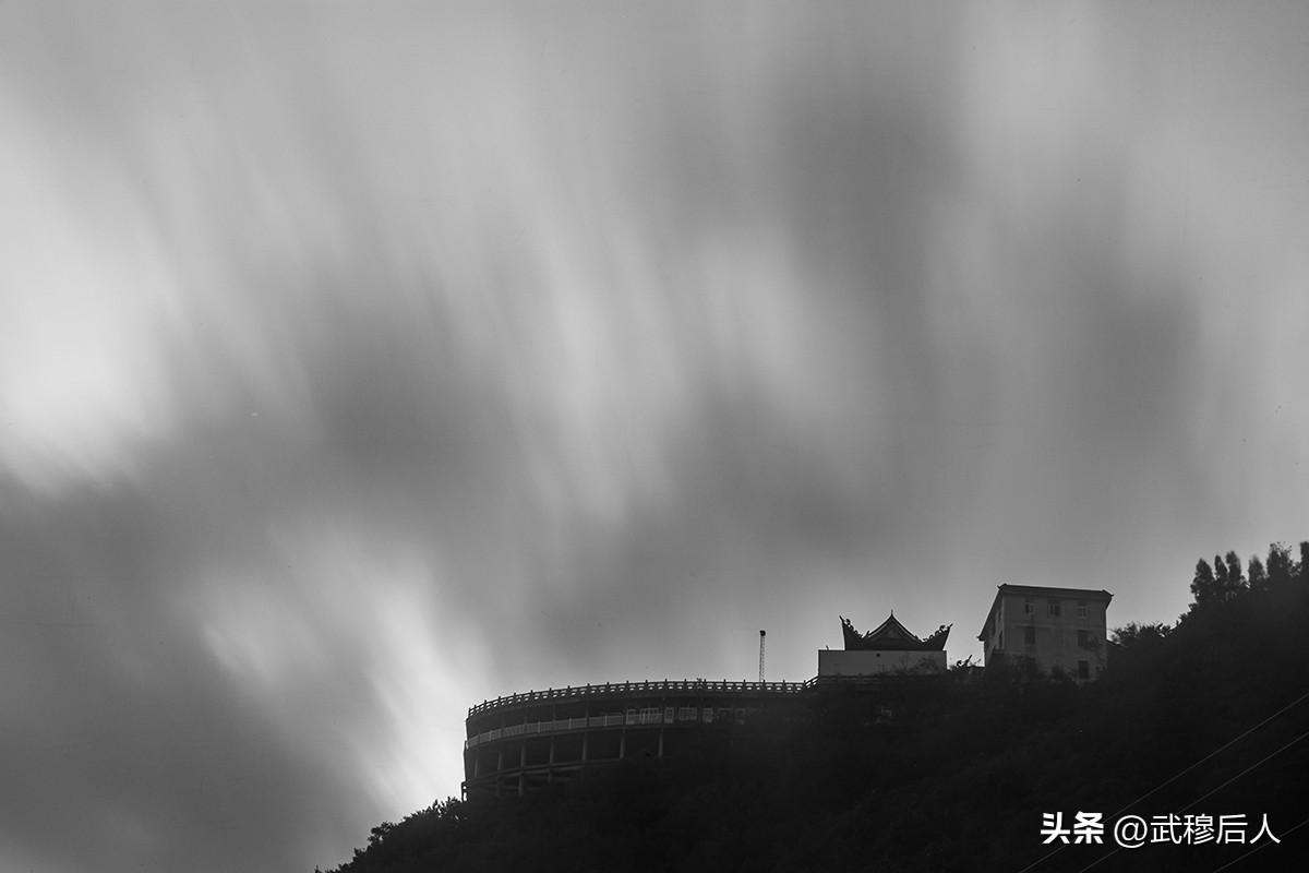 场景       阴云低垂，巨岩默立。荒屋与电杆依山傍海，长曝光抚平了水面与流云