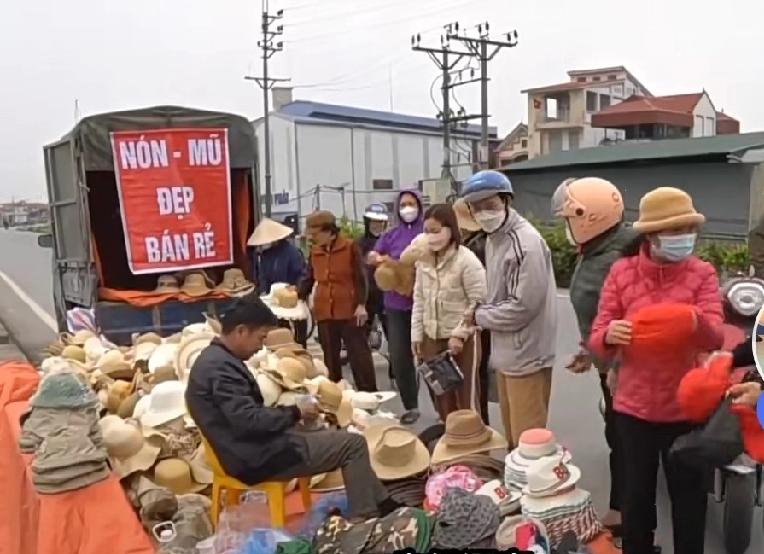 这是一摊贩在一条公路旁临时摆摊交易照片。
         仔细看这张照片，一辆