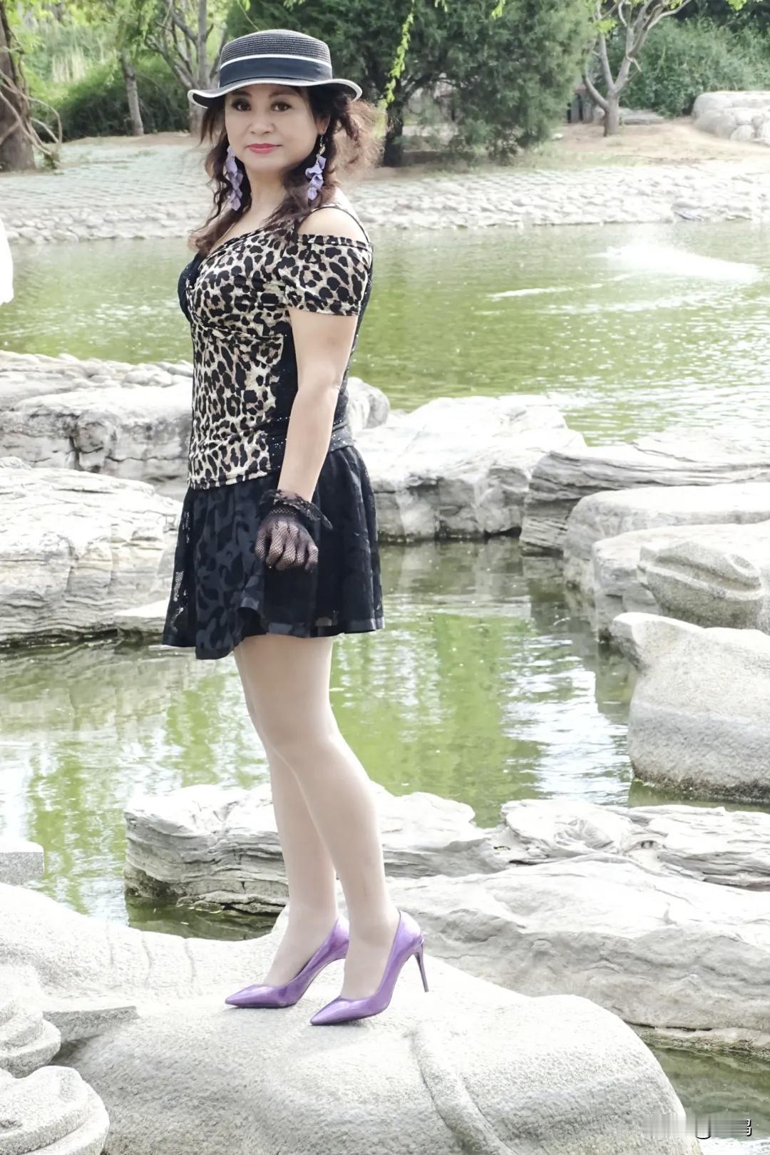 哇塞，想象一下，一位女士站在湖边石头上，身着豹纹裙，那画面简直太有冲击力了。豹纹