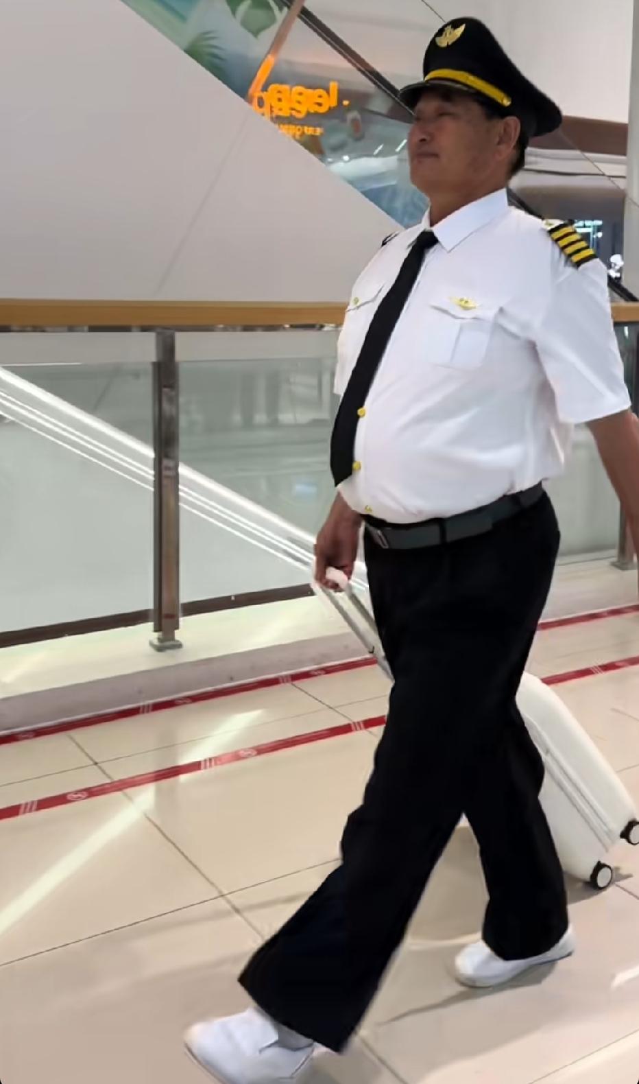 大衣哥穿着机长制服，拉着行李箱，走在商场里。网友笑称“机长文”。

大衣哥这些年