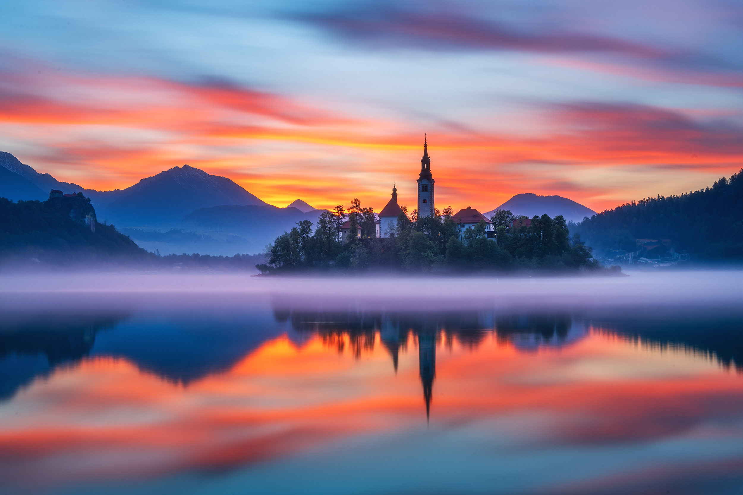 阿尔卑斯脚下的蓝宝石 —— 布莱德湖。湖心岛教堂尖顶刺破晨雾，古堡对望雪峰，湖面