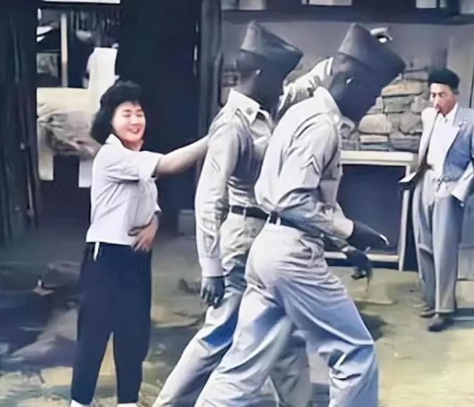 1952年，一名南朝鲜女子给两名美军做完服务后，当着老公的面热情地送大兵们离开。