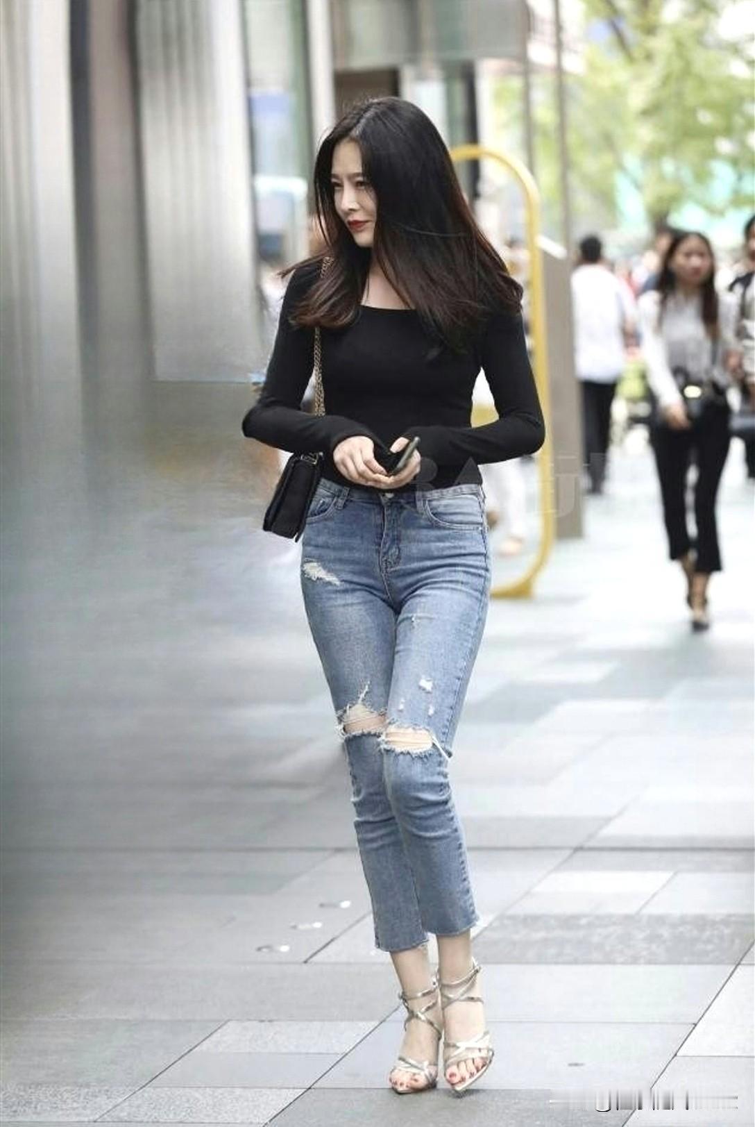 都市时尚风，黑色上衣搭配破洞牛仔裤，自信步伐