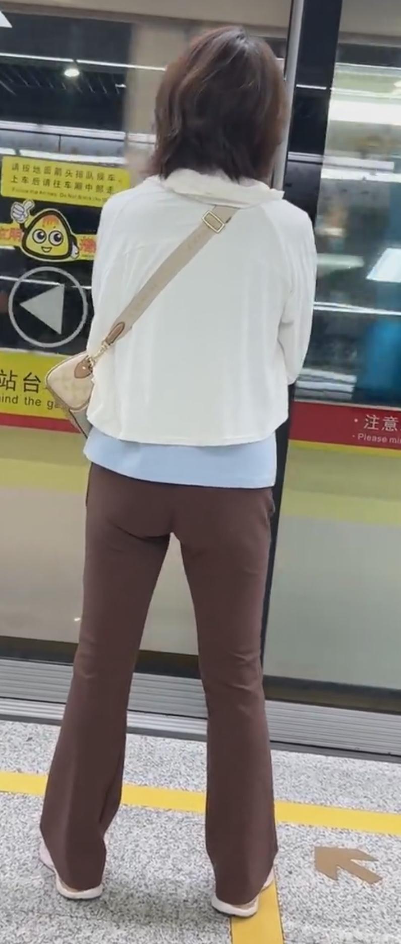 这人在等地铁，背对镜头。