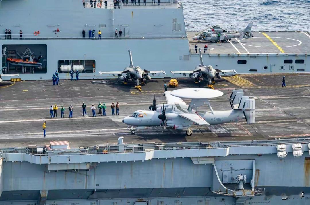 法国“戴高乐”号航母的甲板运作场景，清晰展现了其主力舰载机阵容。
近处是一架E-