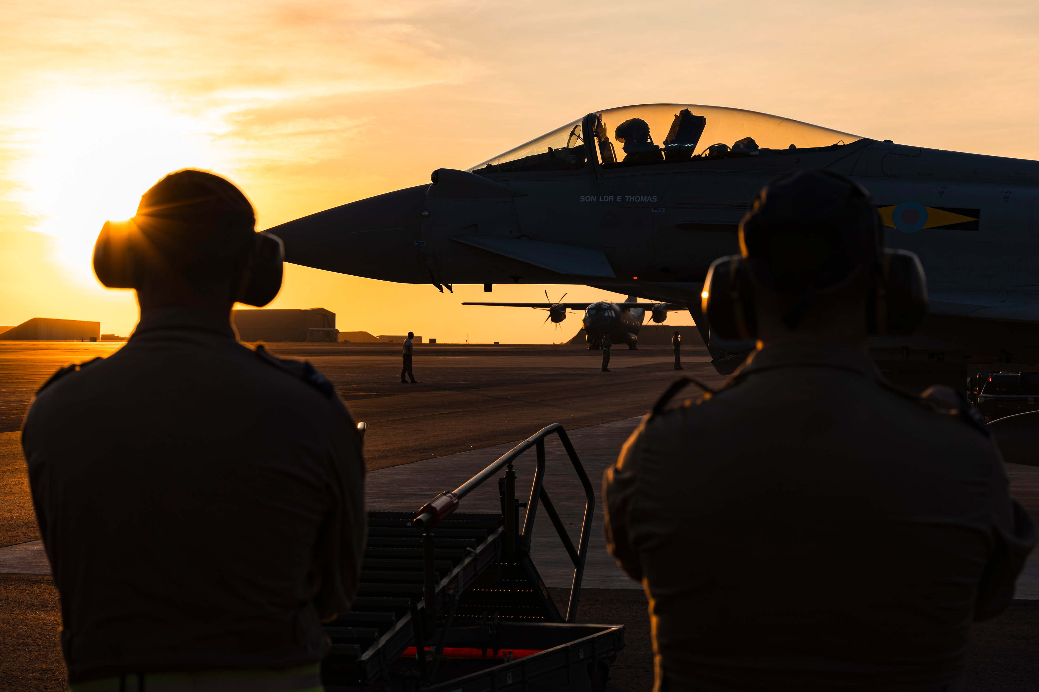 星空下，战鹰列阵机场，参加黑黢黢演习的英国皇家空军航空兵正在进行起飞前的准备；塔