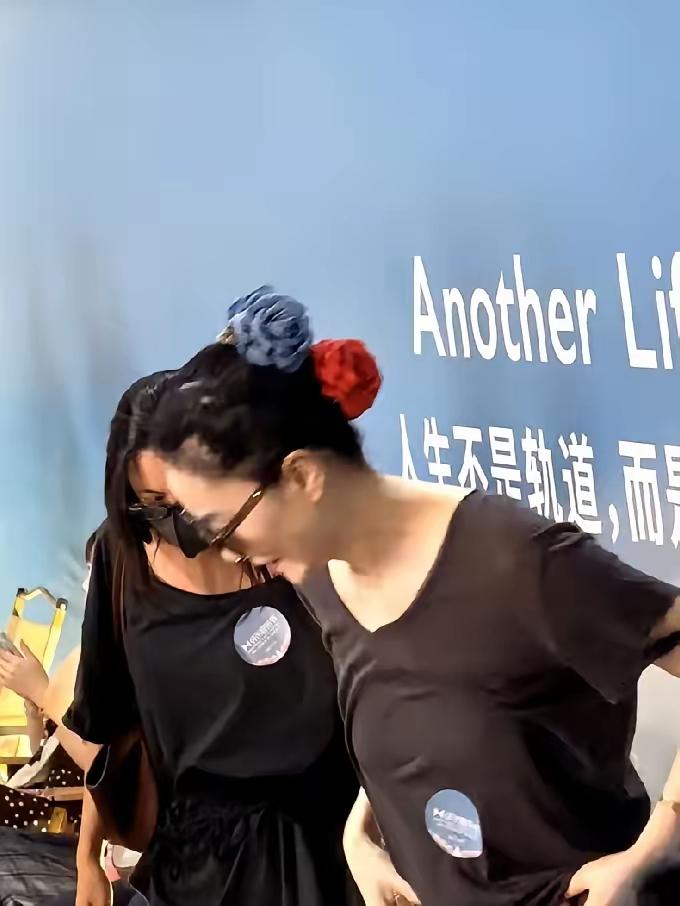 身着朴素的T恤，头戴鲜艳大红花，肆意欢笑，尽情玩耍，从不理会他人的看法，或许这便