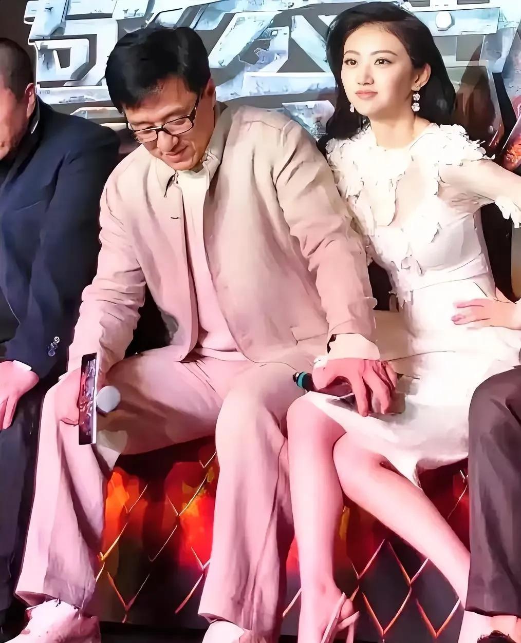 成龙的手不小心放在别人的腿上。旁边的美女，坐到成龙的身边，尽管博到了眼球，也不能