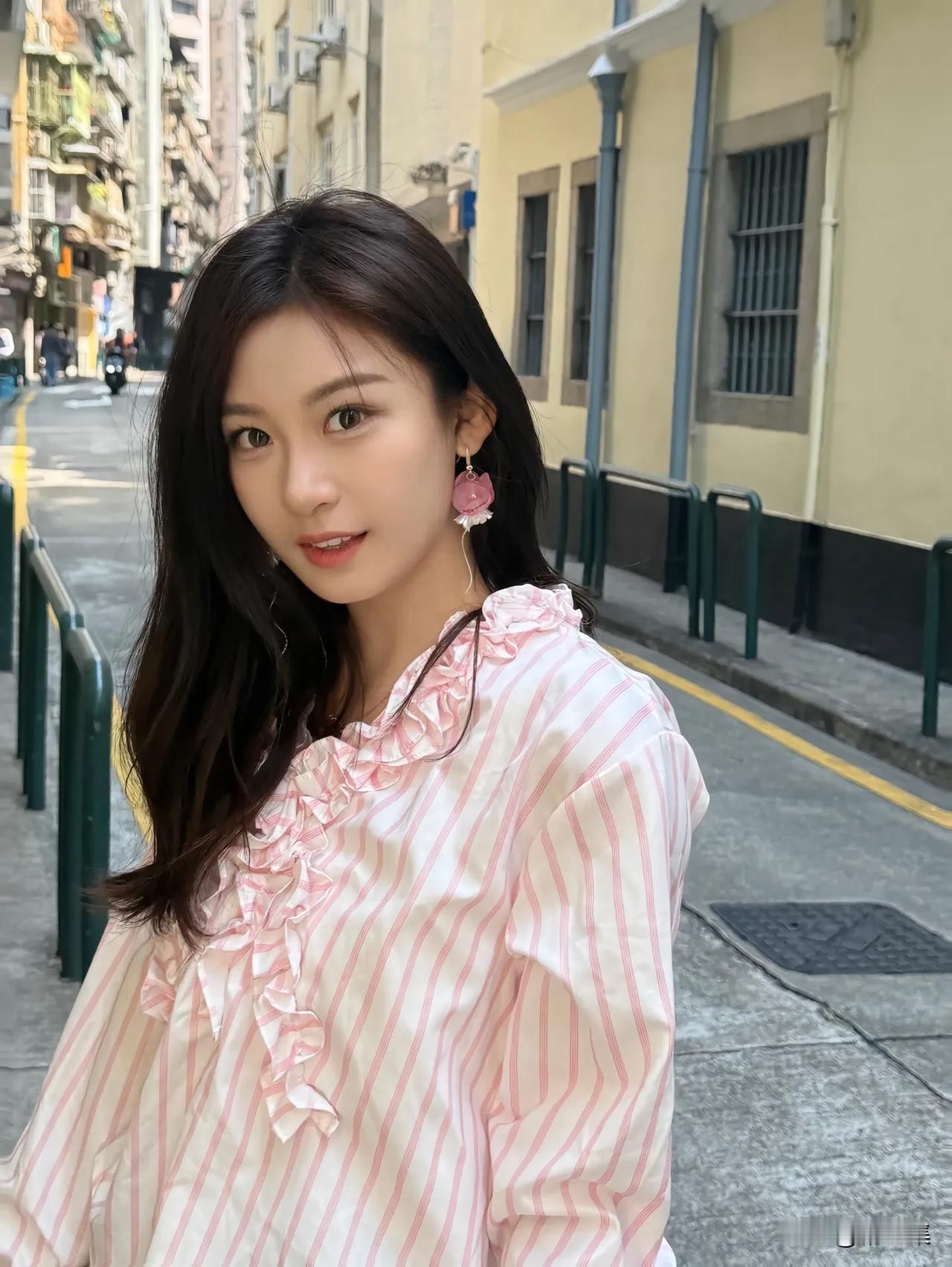 粉衣美人倚街边，笑语如花映日妍。