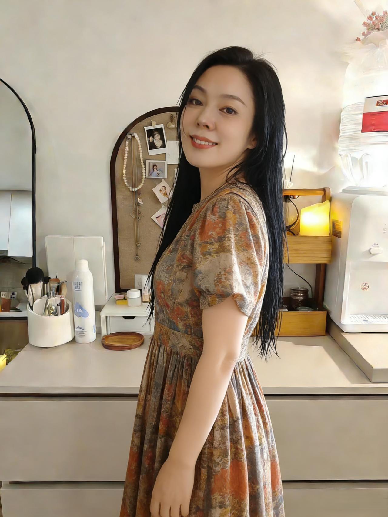 暖日熏风拂画檐，碎花裙上蝶翩翩。
长发垂肩覆鬓边。
一笑惊开帘外柳，半颦蹙损镜中