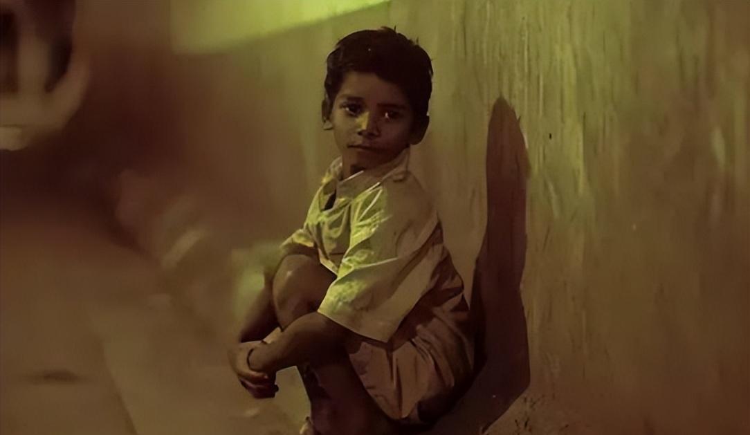 1987年，印度火车站，5岁的弟弟觉得不舒服，哥哥让他躺一会，自己去找食物。弟弟