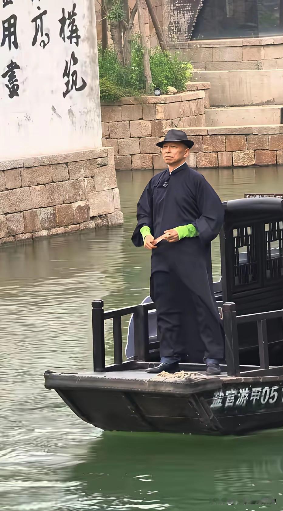 张朝阳身着长衫，头戴礼帽立于船头，试图佯装成地方党员前去接头。
他亮出绿袖暗号，