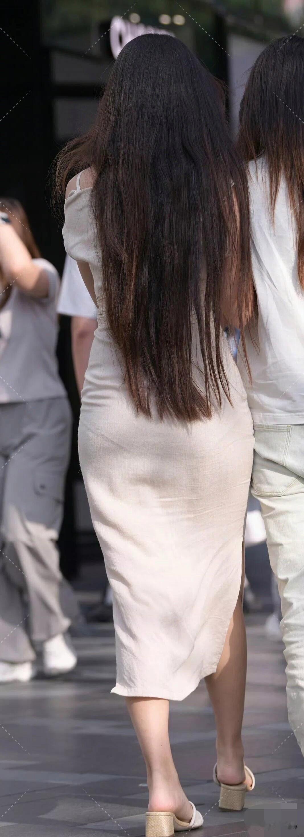 两个人手挽手在街上散步。