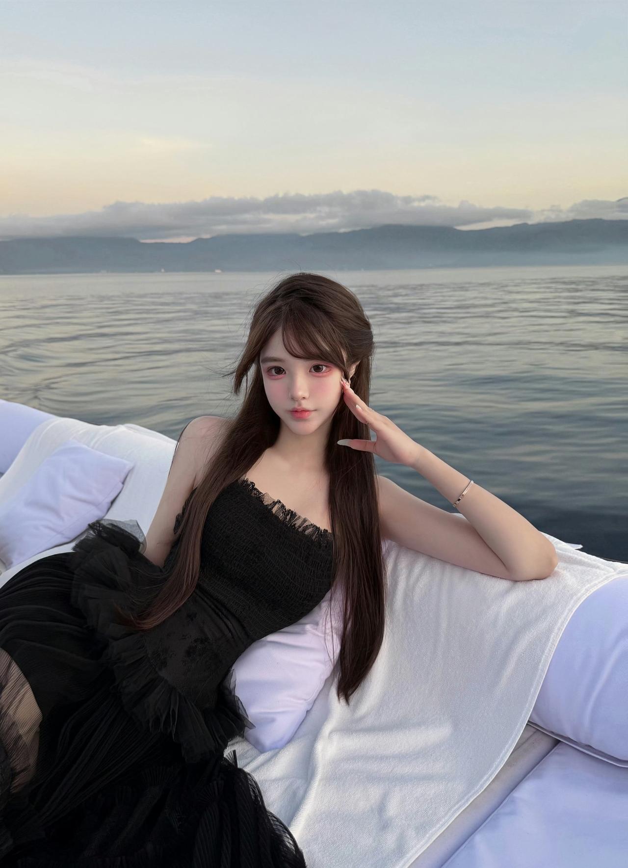 在日落时分赴一场海上约会，黑纱裙摆随晚风轻扬，把所有浪漫都藏进这片温柔暮色里。