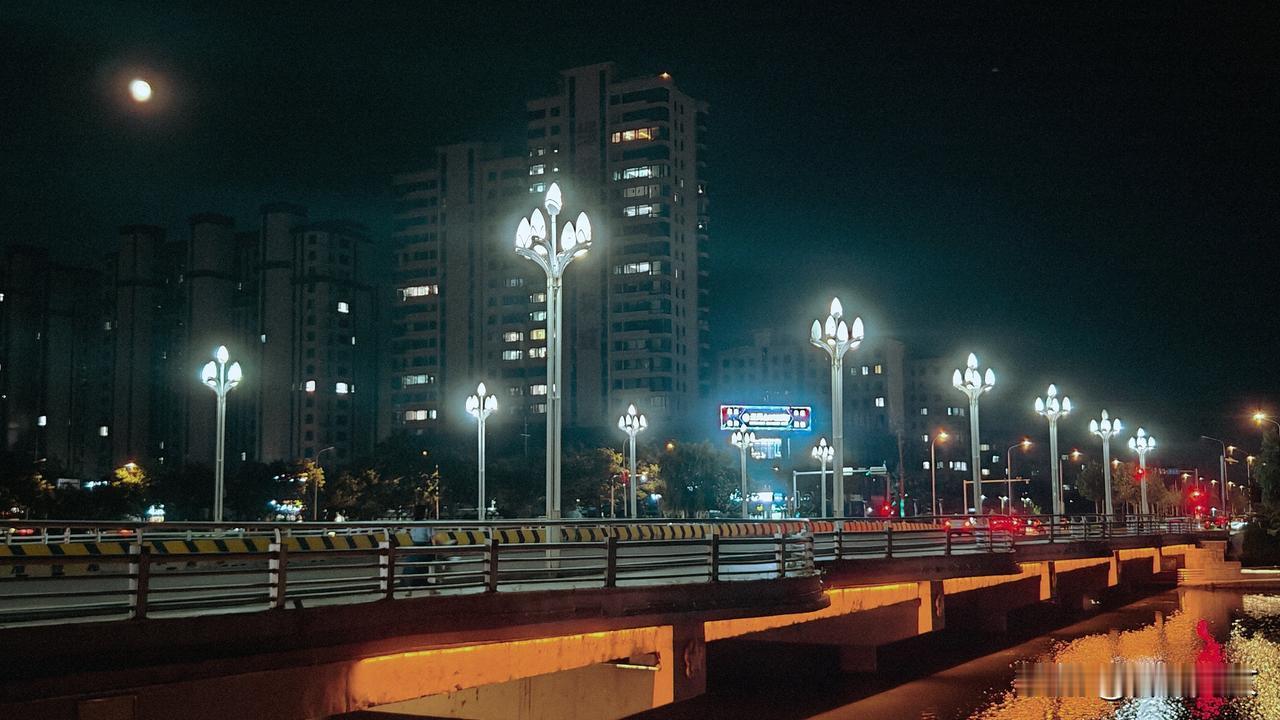 明月当空，灯火辉煌，车来人往。美丽的夜晚，热闹的小城。