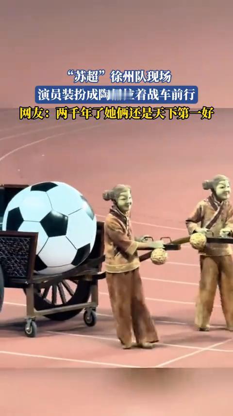"苏超"徐州队现场，演员装扮成陶俑拉着战车前行。
网友：两千年了，她俩还是天下第