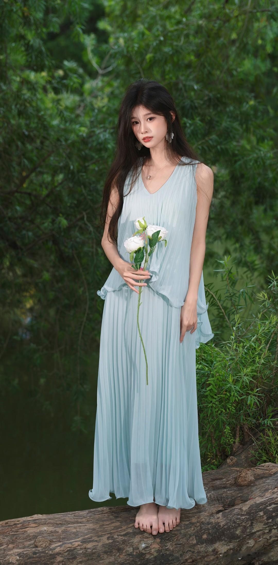 绿衣美人倚绿水，花影摇曳似仙姿。