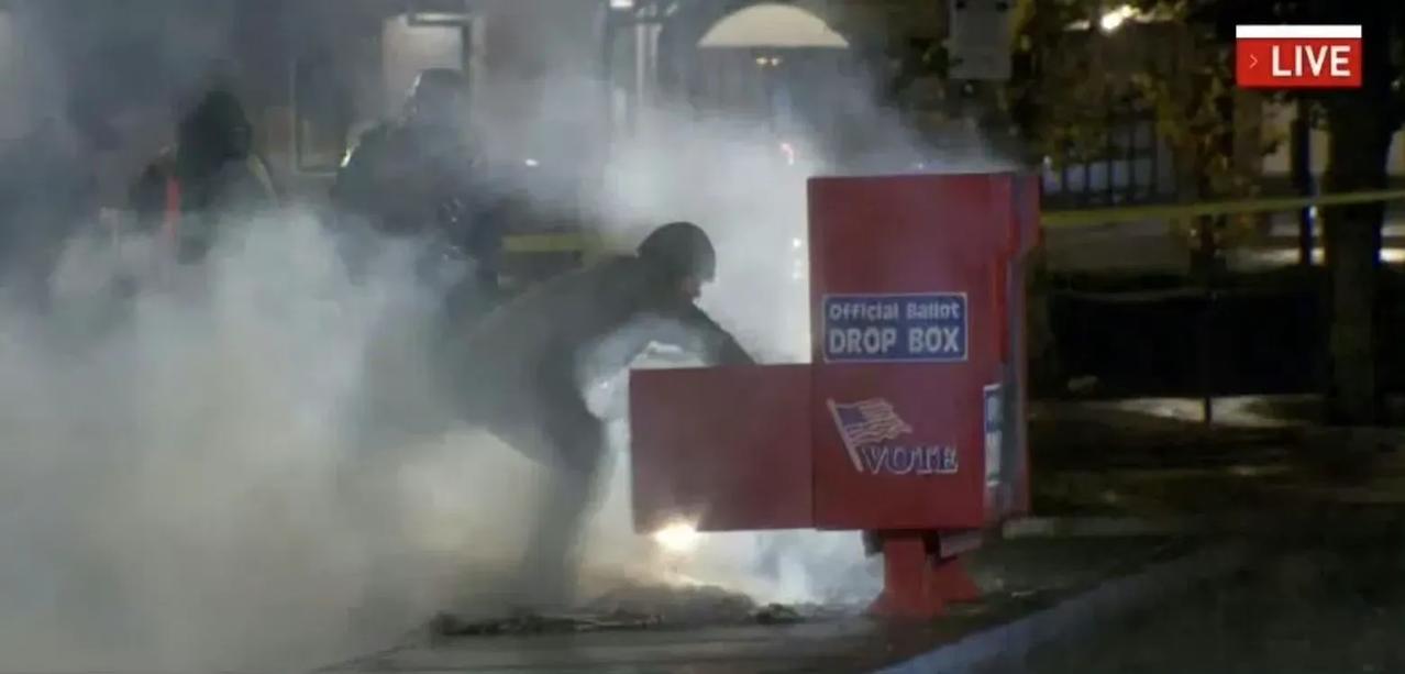 当地时间今天上午，在华盛顿州温哥华市一个正在冒烟的投票箱内，有人从里面拿出了正在