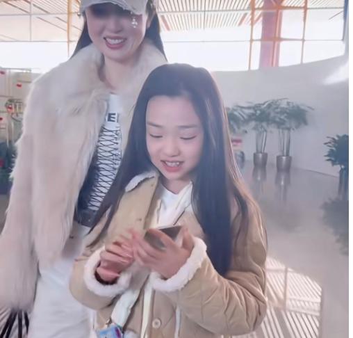 今日小年，
董璇和10岁女儿小酒窝现身北京机场。
董璇一身温柔的米白休闲穿搭，