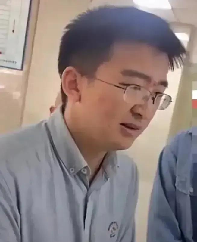 我突然同情起这个年轻老师来了！
看相片，一个穿着普通，戴着眼镜，低着头，像一个做