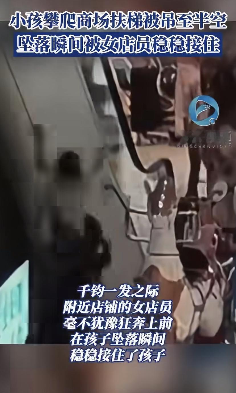 湖北黄冈一商场里，有个小孩贪玩爬扶梯，结果被挂到半空，眼看就要掉下来!旁边店铺的
