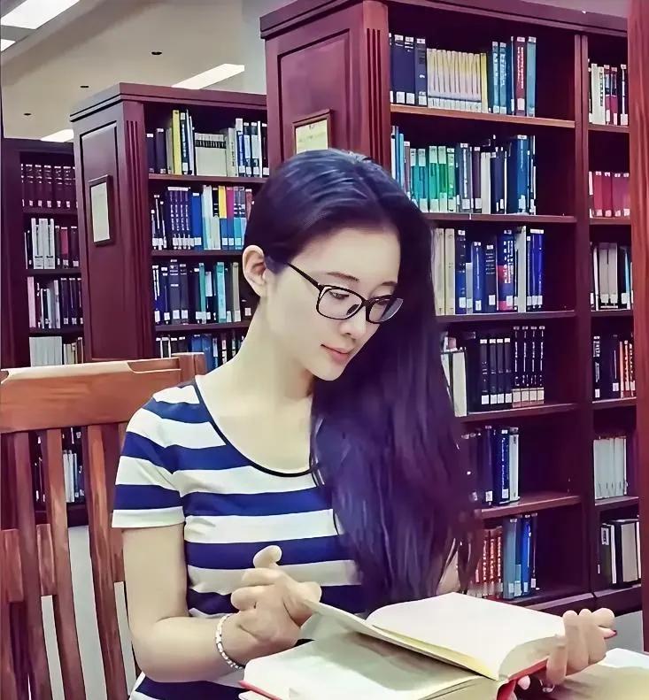 坐在图书馆里的杜星霖，白净，柔美，乌发自然地倾泻一边，秀色眼镜书写着与众不同的高