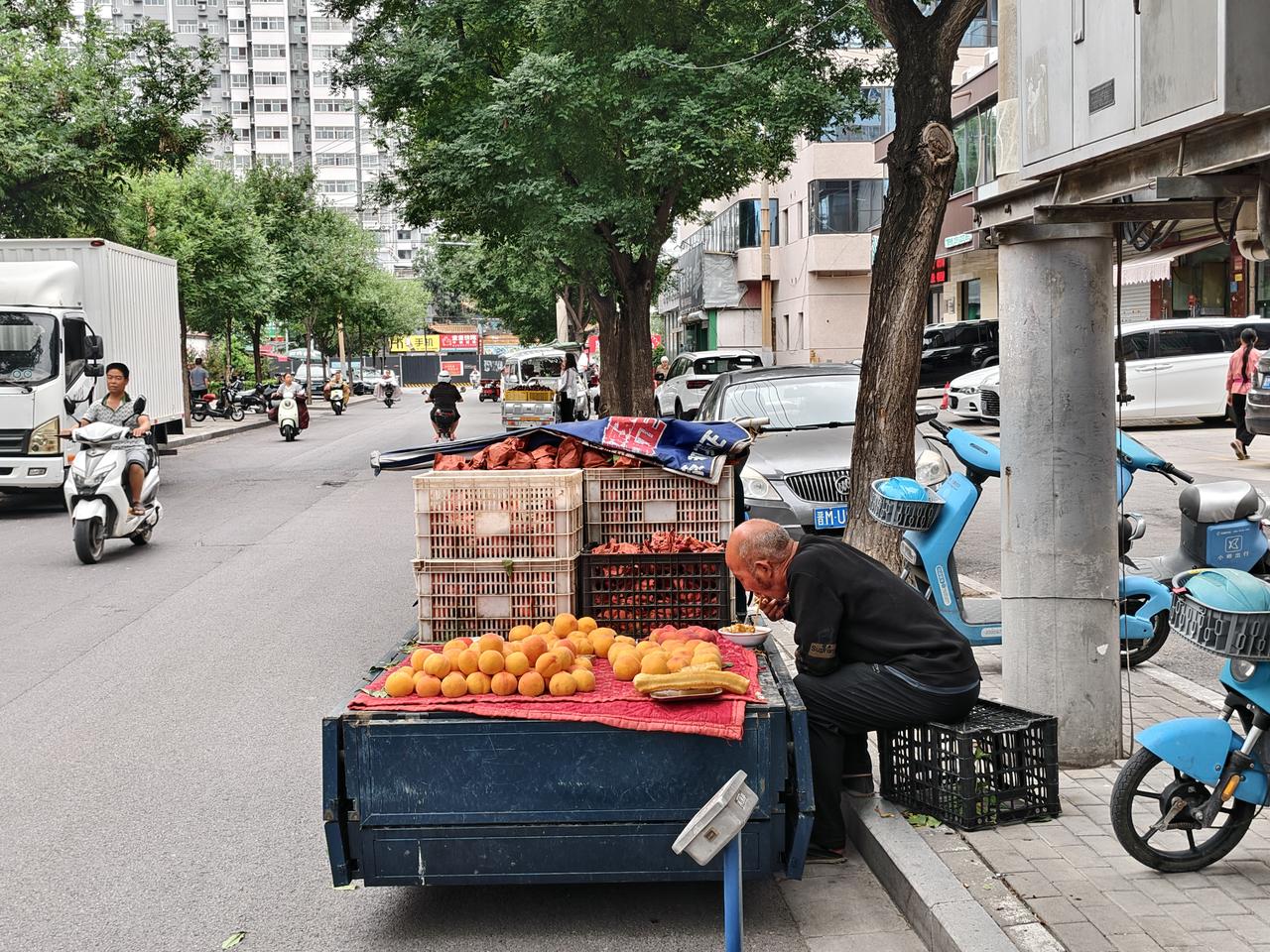 在运城盐湖西街，一位老师傅正埋头在自家的三轮车上吃早餐，一碗豆腐脑，配一根油条，