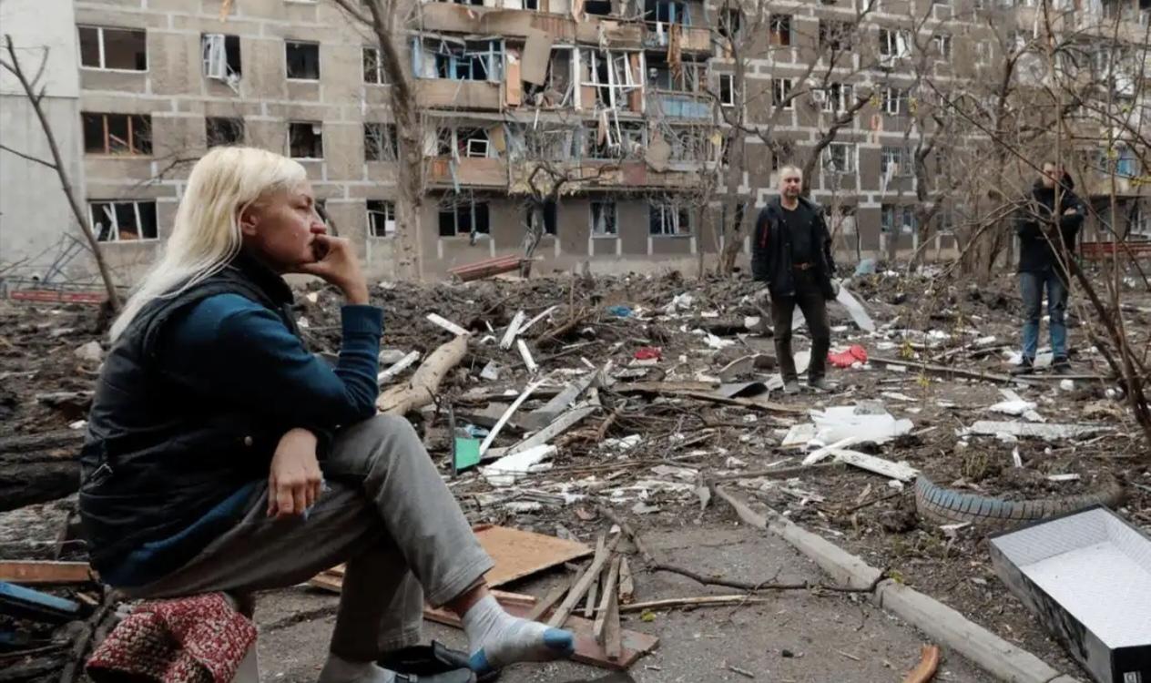 她坐在那堆破烂儿中间，脚上那对蓝白相间的袜子灰头土脸的，手指头无聊地戳着那些破砖